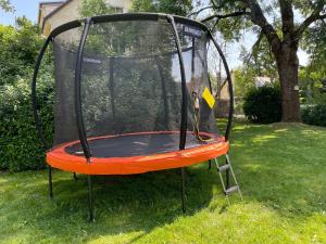 an orange and black trampoline in a yard at Apartmán Maya in Horní Planá