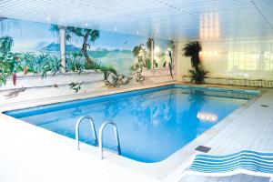 a large swimming pool with a mural on the wall at Hotel Schützenhof in Eitorf