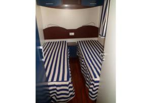 - 2 lits dans une chambre à rayures bleues et blanches dans l'établissement Feriendorf Le Tamerici Mobilehome Asinara für 5 Personen, à Marina di Cecina 17 autres photos