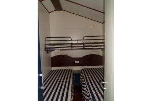 Cette chambre dispose de lits superposés. dans l'établissement Feriendorf Le Tamerici Mobilehome Arno für 6 Personen, à Marina di Cecina 17 autres photos