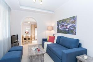 ein Wohnzimmer mit einem blauen Sofa und einem TV in der Unterkunft Villa Yakinthi in Ammoudi