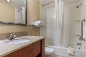 a bathroom with a sink and a tub and a toilet at Suburban Studios Arlington Heights Elk Grove in Arlington Heights +22 photos