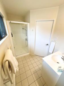 a bathroom with a shower and a sink at Studio Stay Narrow Neck Beach in Auckland