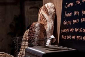 a basket with a loaf of bread next to a chalkboard at Story Hotel Riddargatan, part of JdV by Hyatt in Stockholm