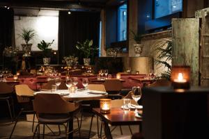 a dining room with tables and chairs and candles at Story Hotel Riddargatan, part of JdV by Hyatt in Stockholm