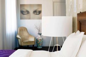 a bedroom with a bed and a chair and a lamp at Story Hotel Riddargatan, part of JdV by Hyatt in Stockholm
