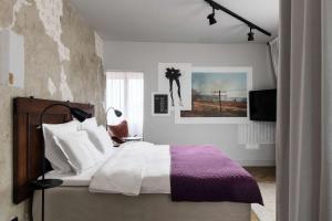a bedroom with a bed with white and purple sheets at Story Hotel Riddargatan, part of JdV by Hyatt in Stockholm