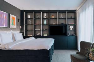 a bedroom with a large bed and a television at Story Hotel Riddargatan, part of JdV by Hyatt in Stockholm