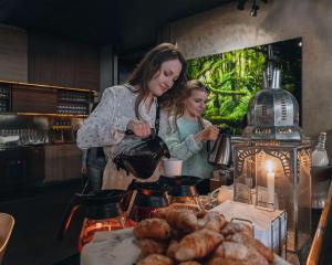a woman standing next to a table with food at Story Hotel Riddargatan, part of JdV by Hyatt in Stockholm
