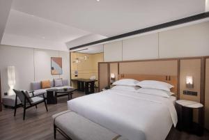 a bedroom with a large bed and a living room at Days Hotel by Wyndham Changsha Yuhua West in Changsha
