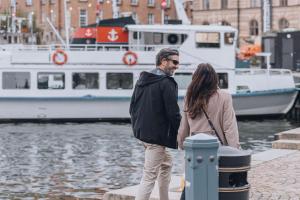 a man and woman standing on a dock near a boat at Story Hotel Riddargatan, part of JdV by Hyatt in Stockholm