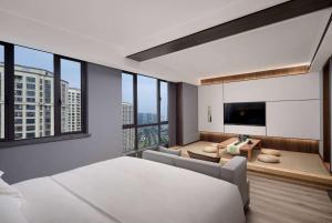 a bedroom with a large bed and a living room at Days Hotel by Wyndham Changsha Yuhua West in Changsha +9 photos