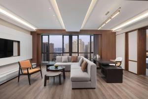 a living room with a couch and a large window at Days Hotel by Wyndham Changsha Yuhua West in Changsha