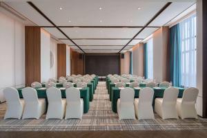 a conference room with tables and chairs and a screen at Days Hotel by Wyndham Changsha Yuhua West in Changsha