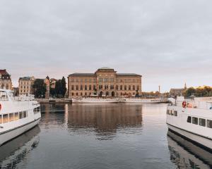 two boats in the water in front of a building at Story Hotel Riddargatan, part of JdV by Hyatt in Stockholm