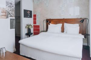 a bedroom with a large white bed with white pillows at Story Hotel Riddargatan, part of JdV by Hyatt in Stockholm