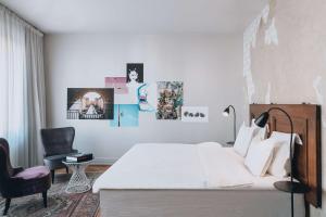 a bedroom with a white bed and a chair at Story Hotel Riddargatan, part of JdV by Hyatt in Stockholm