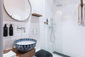 a bathroom with a blue and white sink and a shower at Story Hotel Riddargatan, part of JdV by Hyatt in Stockholm