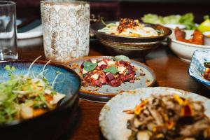 a wooden table with plates of food on it at Story Hotel Riddargatan, part of JdV by Hyatt in Stockholm