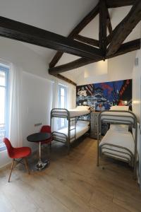 Habitación con 2 literas, mesa y sillas. en The 3 Ducks Eiffel Tower by Hiphophostels, en París