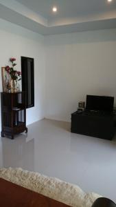 a living room with a white floor and a mirror at Baan Peaceful Villa 1, Ao Nang in Krabi town