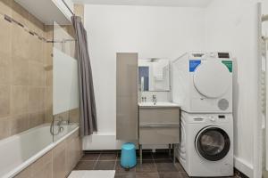 a bathroom with a washing machine and a sink at Grand Appart Rénové Paris et Disneyland 4pers in Neuilly-sur-Marne