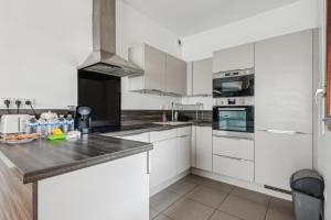 a kitchen with white cabinets and a counter top at Grand Appart Rénové Paris et Disneyland 4pers in Neuilly-sur-Marne