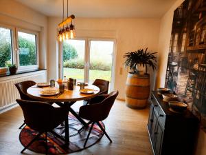 ein Esszimmer mit einem Holztisch und Stühlen in der Unterkunft NEU - Wild Western Wohnung - 110 qm umgeben von Pferden am Fluss in Katzweiler