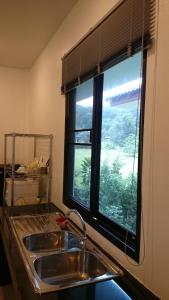 una cocina con fregadero y ventana en Baan Peaceful Villa 2, Ao Nang, en Krabi