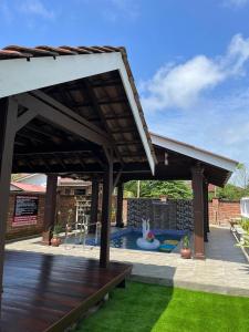 a pavilion with a wooden deck and a pool at Maifa Village Chalet in Kuala Terengganu