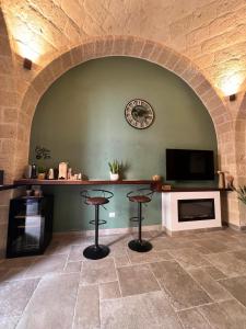 a room with an archway with a tv and two stools at Nicole Suite in San Ferdinando di Puglia