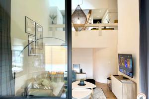 a living room with a couch and a table at Le White Pearl - Marina - Terrasse in Deauville