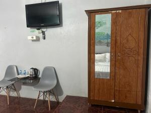 Camera con tavolo, TV e porta in legno di Nhà Nghỉ Mấy Kiên a Phan Thiet