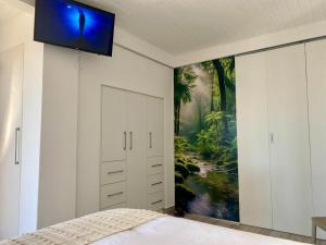 Televisyen dan/atau pusat hiburan di Anura - Luxurious Stay, 100m leap to the Beach!