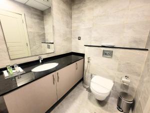 a bathroom with a toilet and a sink and a mirror at Polo Residence Building C1 in Dubai