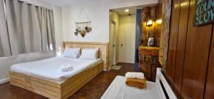 Postel nebo postele na pokoji v ubytování JCGA Apartments' Rustic Chic Cabins-Near Botanical Garden and SM Baguio