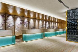 a lobby with turquoise chairs and a wall at RIHGA Royal Hotel Osaka, Vignette Collection by IHG in Osaka
