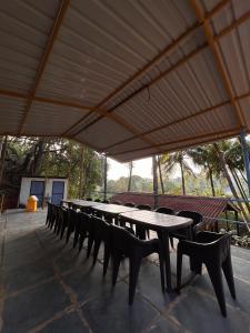 a long table and chairs under a large tent at Mountain Breeze Wooden Cottages in Agonda