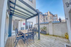 eine Terrasse mit Tisch und Stühlen auf einem Deck in der Unterkunft Excellence - 4 bedrooms in Reims