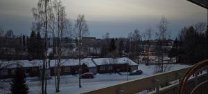 a house with snow on the roof of it at Cozy apartment with view in Kajaani