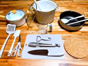 a table with a cutting board with utensils on it at WholeHouse Himeji Castle ホールハウス 姫路 in Himeji