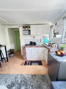a kitchen with white cabinets and a counter top at Pequeno Cielo Staycation in Nairobi