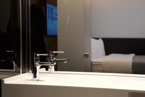 a bathroom with a large mirror and a television at The Z Hotel Victoria in London