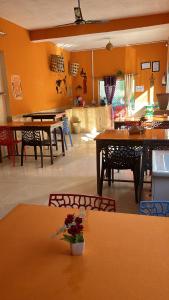 a dining room with tables and chairs and a kitchen at Namaha hotel and cottages in Kanatal +78 photos