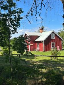 a red barn with a white roof at Skänninge Vimmerby in Vimmerby