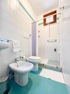 a white bathroom with a toilet and a sink at Casa di Bruca in Marinella di Selinunte +52 photos