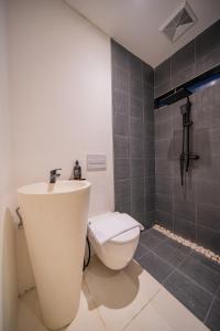 une salle de bain avec des toilettes blanches et un lavabo dans l'établissement Wander Havens, à Canggu 15 autres photos