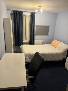 a room with two beds and a desk and a chair at Peace House in Leeds