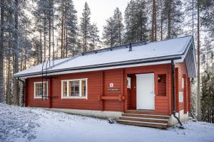 a red cabin with a white door in the snow at Pytkynkulma in Syöte