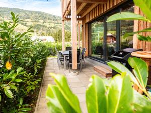 a patio with a table and chairs on a house at Alpenchalét Alpakablick in Sankt Lorenzen ob Murau